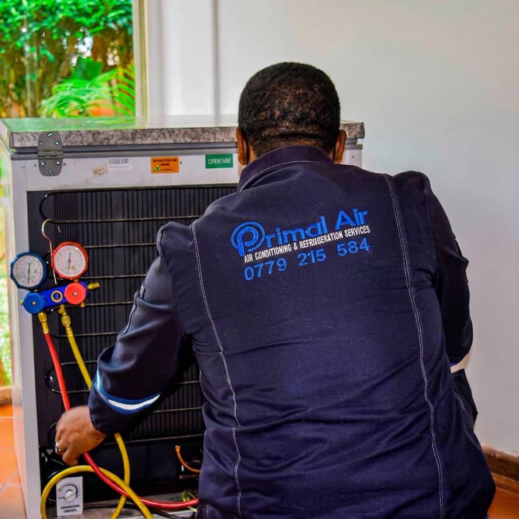 Primal Air technician regassing a fridge with manifold gauges in Harare